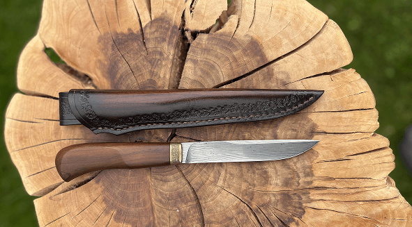 Obal na nůž lemovaný rzí, barvený tmavě hnědou na hřbetu tak aby ladila s rukojetí.