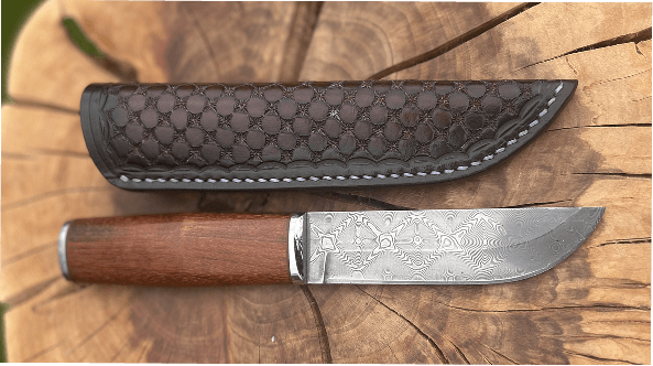 Obal na nůž zdobený hvězdičkami v mřížce tak aby ladil s čepelí, barvený mahagonem.